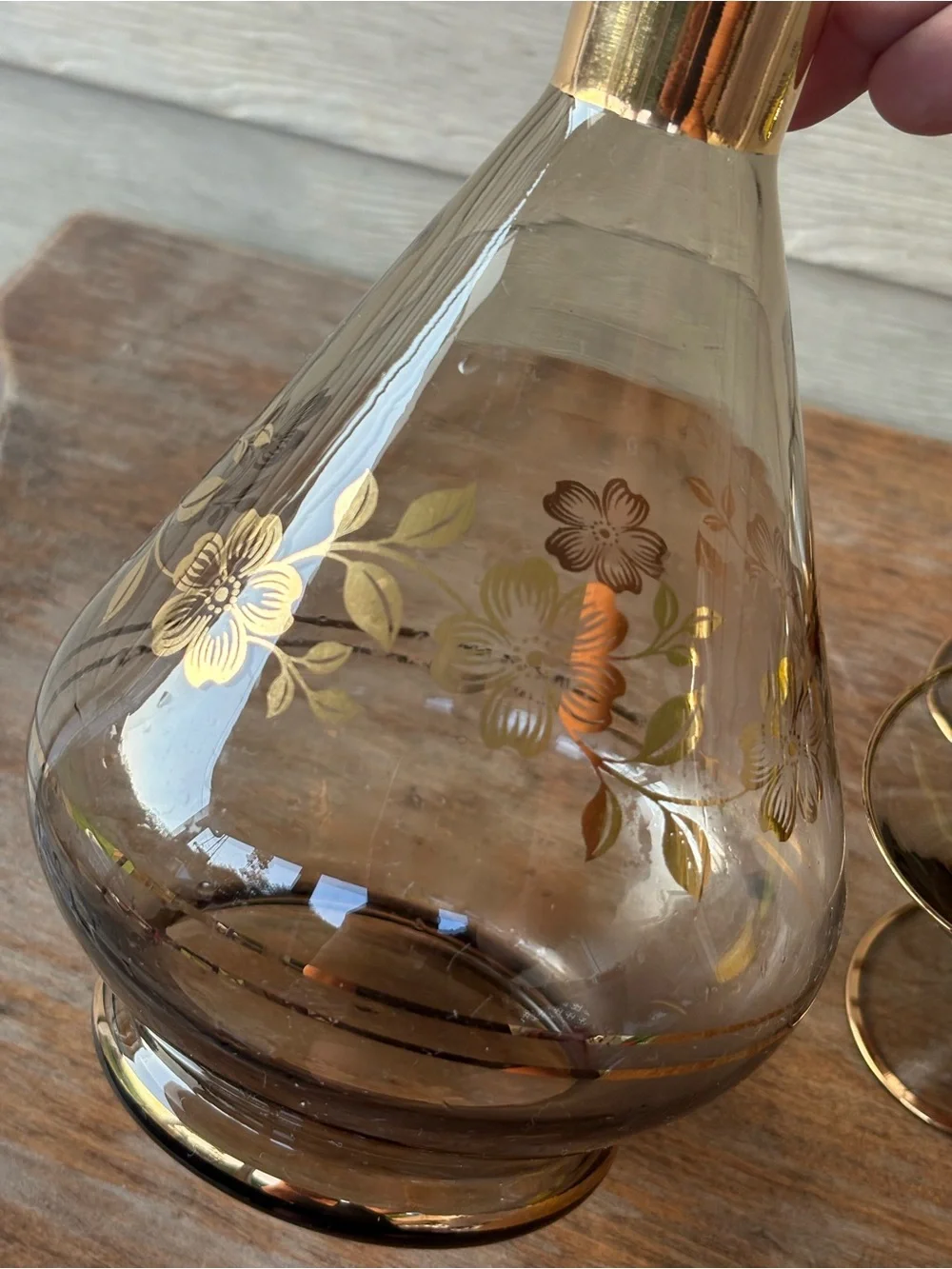 Art Deco decanter set features smoky purple glass adorned with a gold floral